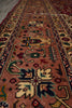 Load image into Gallery viewer, A close-up view of a traditional oriental runner rug with a dusty rose pink field, featuring intricate geometric and floral motifs in navy blue, green, beige, and red.