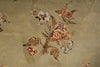 Load image into Gallery viewer, Close-up of a floral textile or rug pattern with embroidered-style flowers in peach, pink, cream, and muted green on a warm beige background with subtle gold-toned linework.