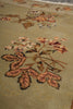 Load image into Gallery viewer, Close-up of a woven textile or rug with a floral pattern in muted peach, brown, cream, and black on a warm beige background.
