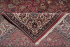 Load image into Gallery viewer, A folded Persian-style area rug with an intricate floral and vine pattern in dusty rose, beige, navy, and brown tones, showing its detailed border and fringe.