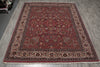 Load image into Gallery viewer, A traditional oriental area rug with a deep red field, ornate floral motifs, and a detailed multi-colored border, laid out on a gray wood-look floor.