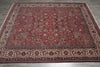 Load image into Gallery viewer, A traditional Persian-style area rug with an intricate floral pattern, featuring a deep red field and detailed borders, laid out on a gray wood-look floor.