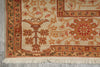 Load image into Gallery viewer, Close-up of a traditional patterned rug corner showing cream, rust, and olive green motifs with fringe along the bottom edge.