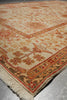 Load image into Gallery viewer, A close-up of an oriental-style area rug with a cream background, featuring traditional floral motifs and borders in rust red, tan, and brown, with a fringed edge visible.
