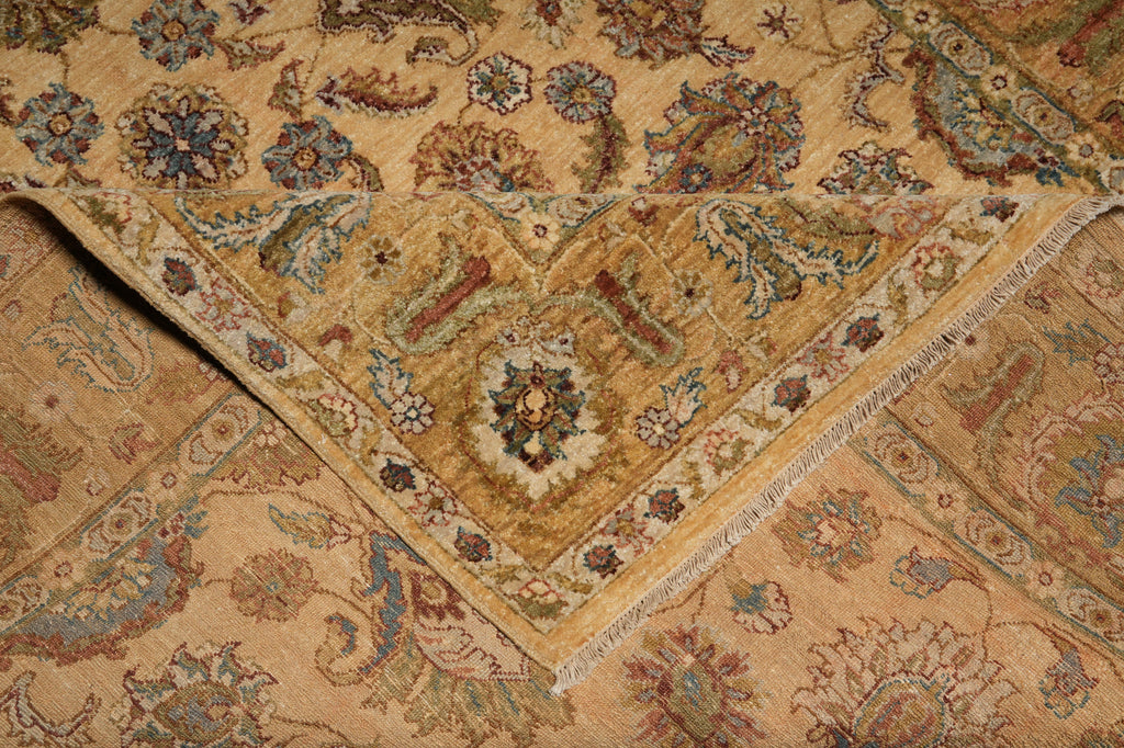 A close-up of a traditional oriental rug with a warm beige background, featuring intricate floral and paisley patterns in muted blue, green, and brown tones.