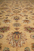 Load image into Gallery viewer, A close-up of a traditional patterned rug with a warm beige background and ornate floral motifs in muted blue, brown, and rust tones.