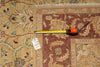 Load image into Gallery viewer, A close-up of a patterned area rug with a tape measure laid across it and a white tag attached, showing the rug's dimensions and design details.