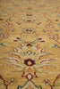 Load image into Gallery viewer, Close-up of a traditional patterned rug with a warm beige background and floral motifs in muted red, green, and cream.