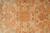 Load image into Gallery viewer, A close-up of an ornate patterned rug or textile with a central medallion and symmetrical floral motifs in warm beige, tan, rust orange, and muted brown tones.