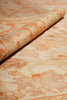 Load image into Gallery viewer, A close-up of a patterned fabric or rug roll showing a beige base with an orange floral or botanical motif.