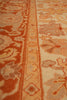 Load image into Gallery viewer, Close-up of a patterned area rug featuring traditional floral and geometric motifs in terracotta orange, beige, and muted brown tones.