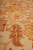 Load image into Gallery viewer, Close-up of a patterned rug or textile with an ornate floral motif in warm beige, tan, orange, and brown tones.