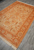 Load image into Gallery viewer, An oriental-style area rug with a warm orange and beige floral pattern, laid out on a gray wood-look floor.