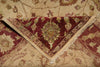 Load image into Gallery viewer, A close-up of a folded area rug showing its intricate traditional pattern in burgundy red, beige, and muted green tones.