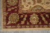 Load image into Gallery viewer, Close-up of an ornate area rug corner showing a deep burgundy field with cream floral motifs, a beige border, and a fringed edge on a gray floor.