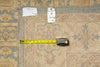 Load image into Gallery viewer, A square area rug with a beige, blue, and yellow floral pattern, shown with a yellow tape measure and two white inventory tags on a matching rug surface.