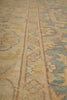 Load image into Gallery viewer, Close-up of a traditional patterned area rug with a beige base and blue, yellow, and brown ornamental motifs.
