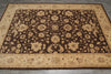 Load image into Gallery viewer, A rectangular area rug with an ornate floral and vine pattern, featuring a dark brown center field, beige borders, and small bird motifs along the lower border, shown on a gray tiled floor.