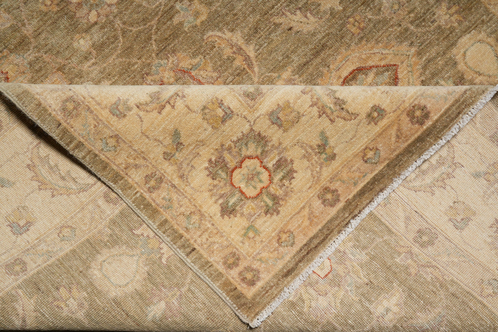 A folded area rug with a traditional floral and medallion pattern, showing both the beige front side and the brown reverse side.