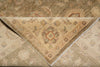 Load image into Gallery viewer, A folded area rug with a traditional floral and medallion pattern, showing both the beige front side and the brown reverse side.