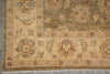 Load image into Gallery viewer, A close-up of an ornate area rug showing its detailed border and floral motifs in beige, brown, and muted red tones.