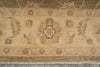 Load image into Gallery viewer, A close-up of a traditional patterned rug with a beige and brown base, featuring a central medallion, floral motifs, and cream fringe at the bottom.