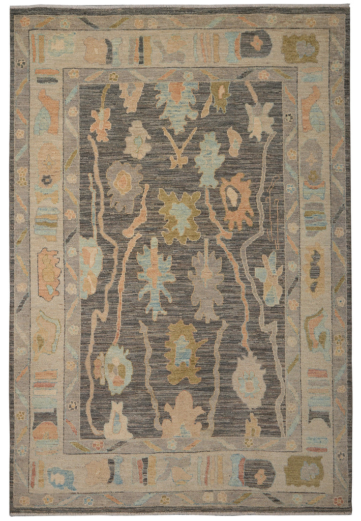 A rectangular area rug with a distressed traditional design, featuring a dark gray central field with muted beige, light blue, and olive green motifs, surrounded by a beige border.
