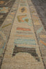 Load image into Gallery viewer, A close-up view of a textured area rug with a traditional geometric pattern in beige, brown, light blue, and muted orange.