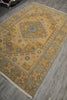 Load image into Gallery viewer, A rectangular area rug with a traditional medallion pattern in beige, brown, and muted blue-gray, shown laid out on a gray wood-look floor.