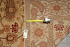 Load image into Gallery viewer, An area rug with a traditional floral pattern in beige, brown, and red, shown with a yellow tape measure and a product tag.