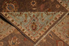 Load image into Gallery viewer, A close-up of a traditional patterned rug with a folded corner revealing a dusty blue-green central field and ornate floral motifs in brown, beige, rust, and cream.