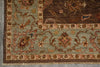 Load image into Gallery viewer, Close-up of an ornate patterned rug corner showing a muted sage green field, dark brown border, and floral motifs in beige, rust, and blue.