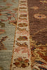 Load image into Gallery viewer, Close-up of a patterned area rug showing a central cream border with floral motifs and adjacent sections in muted green and brown tones.