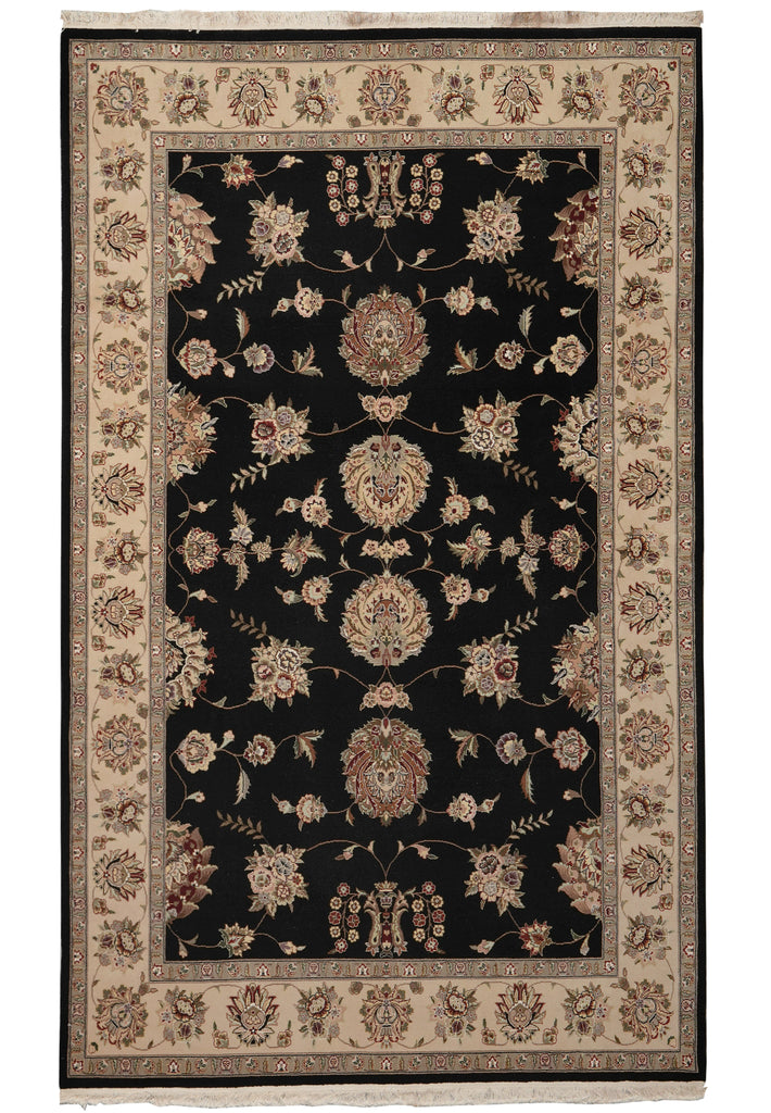 A traditional oriental-style area rug with a black central field, beige floral motifs, and a beige border with red and blue accents.