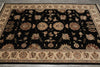 Load image into Gallery viewer, A rectangular area rug with a black center field and ornate floral motifs in beige, brown, and muted red, surrounded by a detailed beige border.