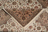 Load image into Gallery viewer, A close-up of an ornate Persian-style area rug with a floral pattern, featuring a central dusty pink triangular panel, cream borders, and white fringe.