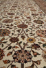 Load image into Gallery viewer, A close-up view of an ornate traditional area rug with a cream background and intricate floral motifs in brown, beige, muted blue, and olive green.