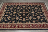 Load image into Gallery viewer, A traditional oriental area rug with a black field, red borders, and beige floral motifs, shown flat on a gray tiled floor.