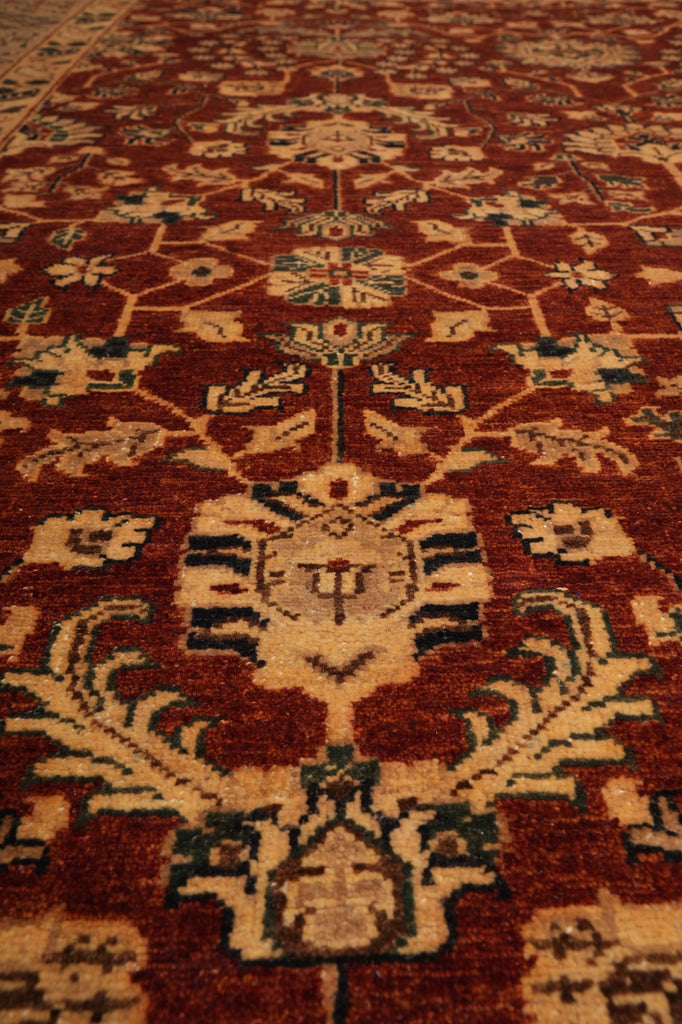 A close-up view of a traditional oriental rug with a deep red-brown field, beige floral medallions, and accents of navy blue and cream.