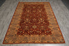 Load image into Gallery viewer, A traditional oriental area rug with a deep red central field and ornate beige, gold, and black floral motifs, laid out on a gray wood-look floor.