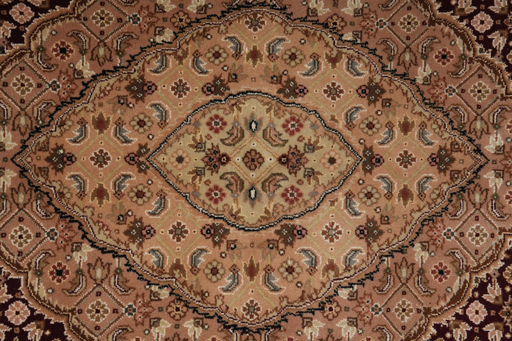 A traditional oriental-style area rug with an intricate floral and geometric pattern in shades of brown, beige, and muted red.