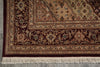 Load image into Gallery viewer, A close-up of an ornate traditional area rug showing its detailed floral pattern, borders, and cream-colored fringe on a gray floor.