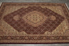 Load image into Gallery viewer, A traditional oriental area rug with an intricate floral pattern, featuring a large central diamond medallion in shades of dark brown, rust red, and beige, laid out on a gray concrete floor.