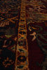 Load image into Gallery viewer, Close-up of a traditional patterned rug with a central ornamental border in gold, beige, and teal, surrounded by deep red and dark brown sections.