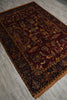 Load image into Gallery viewer, A traditional oriental area rug with an intricate floral and animal pattern, shown laid out on a gray wood-look floor. The rug features a deep burgundy center, dark navy borders, and warm brown and gold accents.