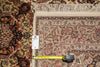 Load image into Gallery viewer, A close-up of an ornate patterned area rug with cream fringe, shown alongside a tape measure and a small product tag. The rug features a complex floral and geometric design in beige, red, brown, and dark accents.