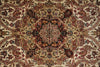 Load image into Gallery viewer, A close-up of an ornate traditional patterned rug with a central medallion and symmetrical floral motifs in beige, rust red, brown, and black.