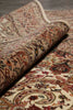 Load image into Gallery viewer, A close-up of a rolled section of a traditional oriental rug showing its detailed floral and scroll patterns in beige, red, brown, and cream tones.