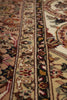 Load image into Gallery viewer, Close-up of an ornate patterned area rug with beige, cream, red, brown, and green tones, showing detailed woven borders and floral motifs.