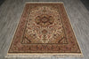 Load image into Gallery viewer, A traditional oriental-style area rug with an intricate floral and medallion pattern, laid flat on a gray wood-look floor. The rug features a warm brown, beige, and red color palette with cream-colored fringe at the bottom.